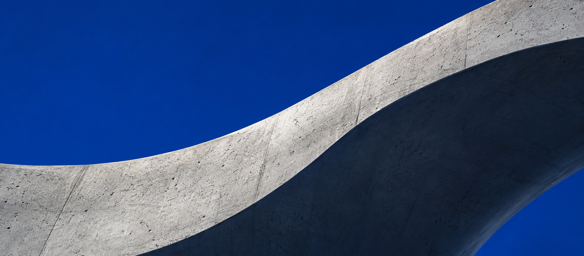 Sweeping concrete architecture against a cobalt sky